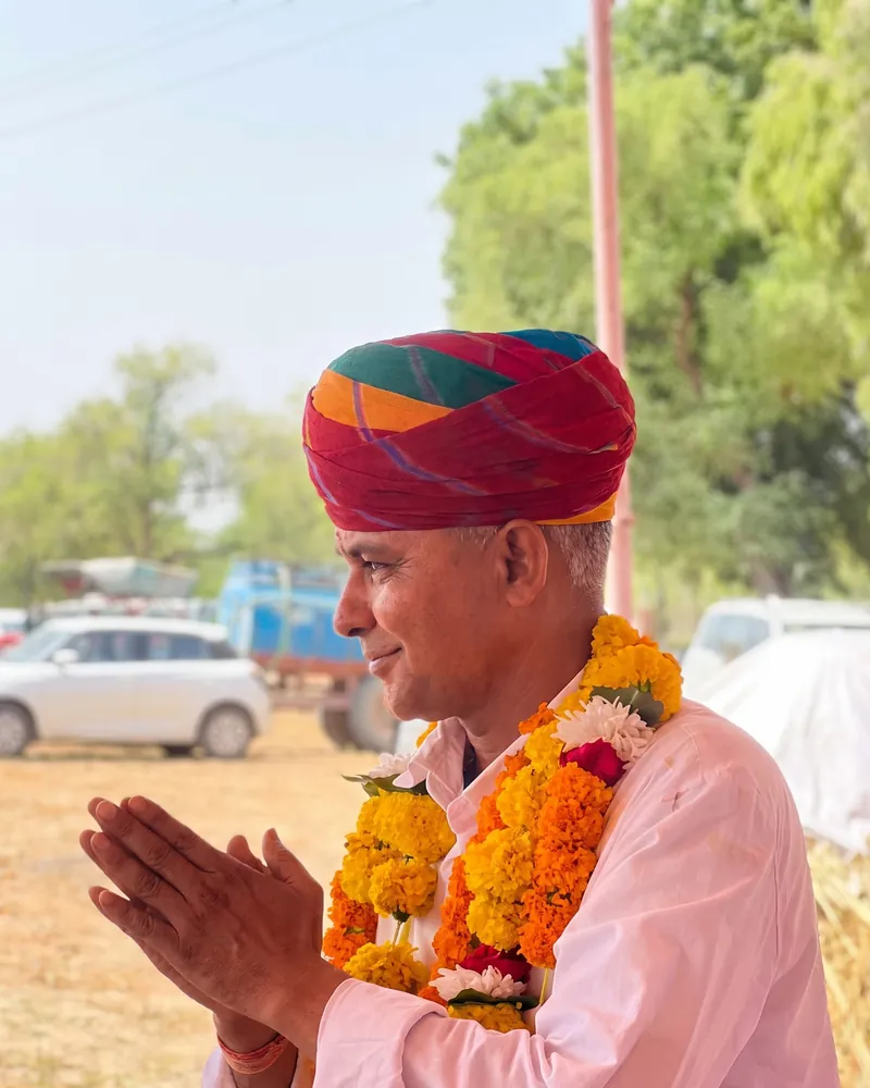 हनुमानराम पटेल, गाँव की सभा में साफ़ा और माला पहने, सबका अभिवादन करते हुए